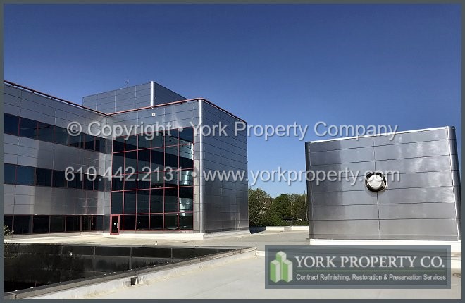 Contractor cleaning dirty stainless steel clad panels.